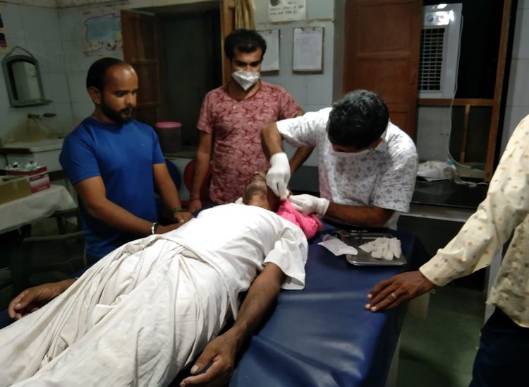 बुजुर्ग के टूटे कानों का उपचार करते चिकित्साकर्मी।