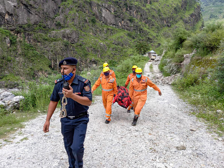 मलबे में मिले शव को ले जाते हुए NDRF के जवान। देर रात बचाव कार्य में दिक्कतें आई थीं, लेकिन सुबह करीब 3.30 बजे से रेस्क्यू फिर तेज कर दिया गया।