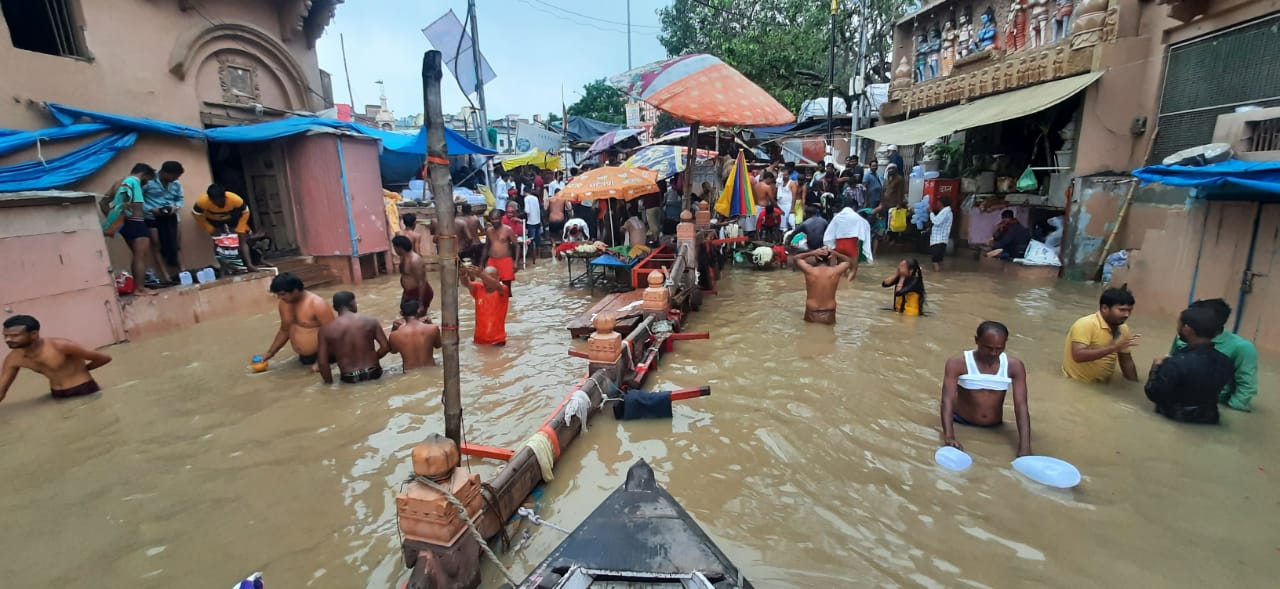 वाराणसी में दशाश्वमेध घाट की ओर जाने वाले रास्ते पर गंगा में आई बाढ़ का पानी भर गया है। श्रद्धालु इसी में स्नान कर रहे हैं।