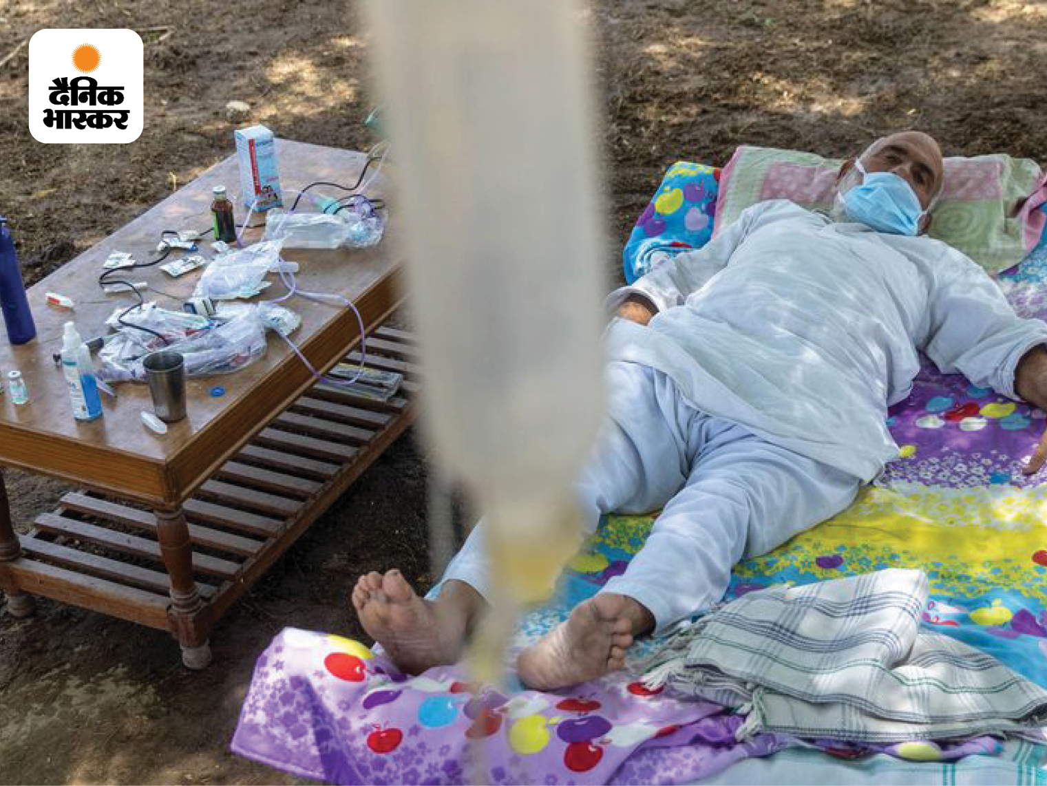 कोरोना की सेकेंड वेव के दौरान कई संक्रमित एक अस्थाई ओपन-एयर क्लिनिक में इलाज करवाने के लिए मजबूर थे। दानिश की यह तस्वीर उत्तर प्रदेश के जेवर जिले के मेवला गोपालगढ़ गांव की है, जिसमें 65 वर्षीय हरवीर सिंह पेड़ के नीचे खाट बिछाकर अपना इलाज करवा रहे हैं।