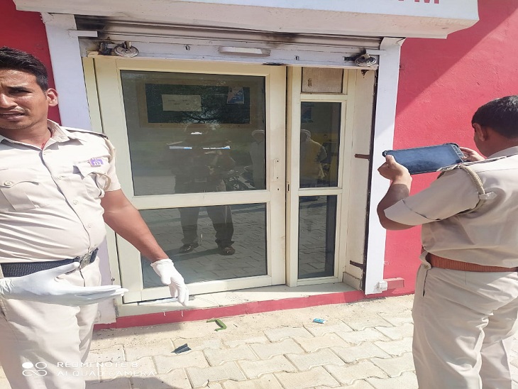 एटीएम बूथ पर लूटपाट की जांच करती पुलिस।