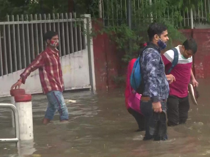 दिल्ली के ITO इलाके में सड़क पर भरे पानी में से गुजरते राहगीर। लोगों को ऑफिस पहुंचने में दिक्कत का सामना करना पड़ा।
