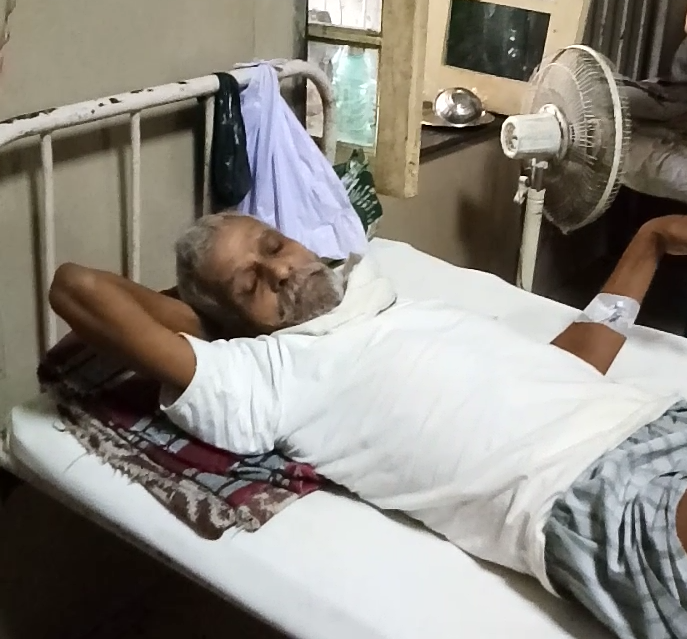 एक दूसरे मरीज के बगल में रखा उसका स्वयं का पंखा