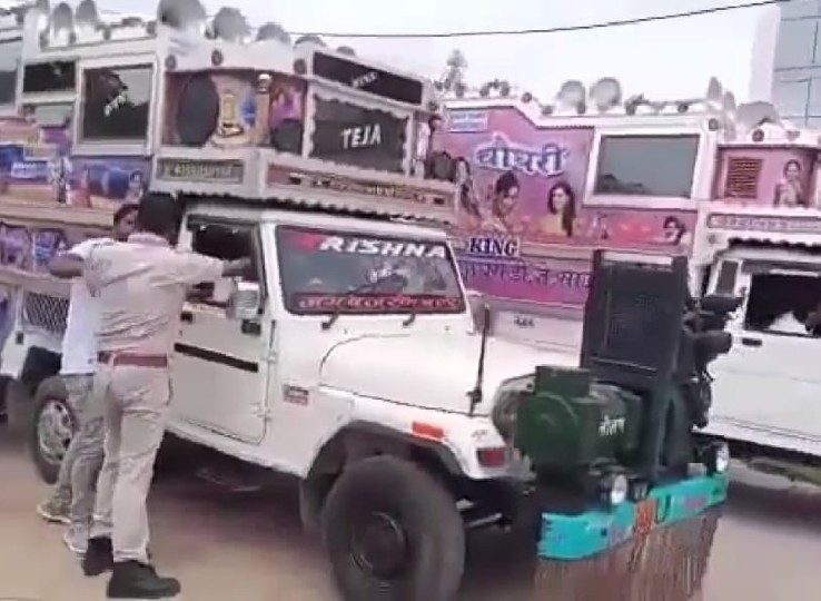 पुलिसकर्मी डीजे वाहन के ड्राइवर से बात करते हुए।