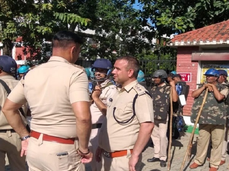 धरनास्थल पर तैनात पुलिस अफसर एक दूसरे से बात करते हुए।