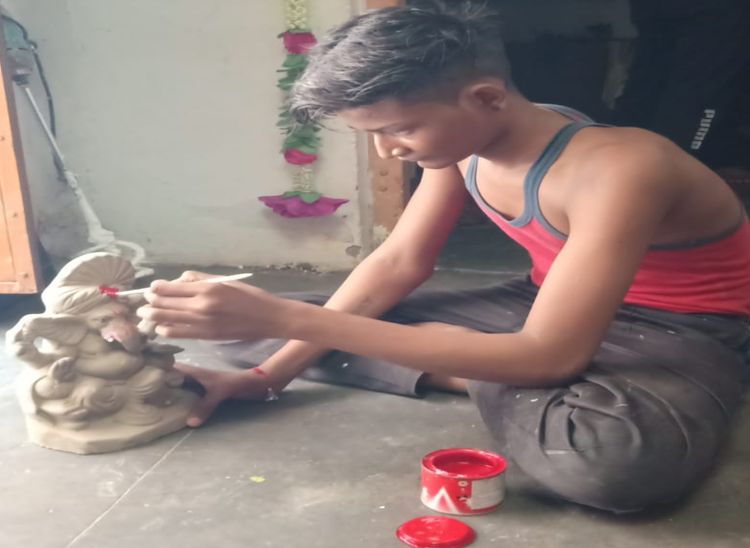 प्रतिमा में रंग भरते हुए हेमन्त प्रजापत।