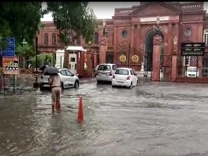अमृतसर के टाउन हाल के बाहर जमा पानी और ड्यूटी पर तैनात पुलिसकर्मी।