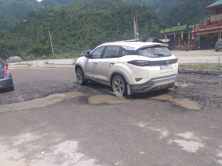 चंडीगढ़-मनाली नेशनल हाईवे पर गड्ढों के बीच से गुजरता टूरिस्ट वाहन