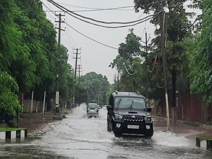 अमृतसर में जलमग्न सड़क से गुजरती गाड़ियां।