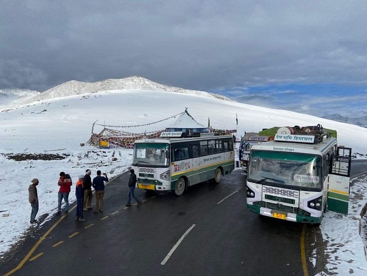 लेह-दिल्ली रूट पर जा रही बस को बीच में रोककर बर्फबारी का लुत्फ उठाते पर्यटक।