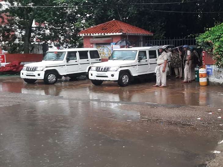 लघु सचिवायल के गेट पर बारिश से बचते हुए ड्यूटी पर तैनात पुलिसकर्मी।