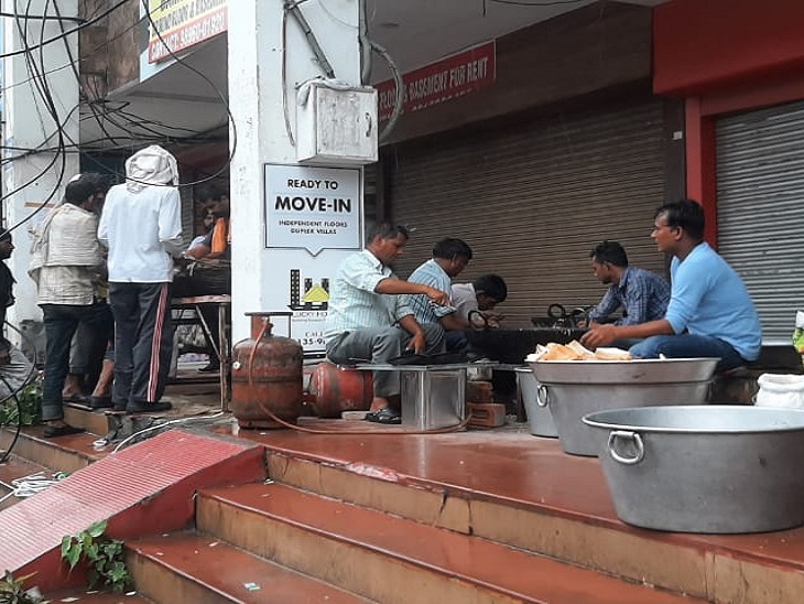 किसानों के लिए बरामदे में बैठकर नाश्ता बनाते लोग।