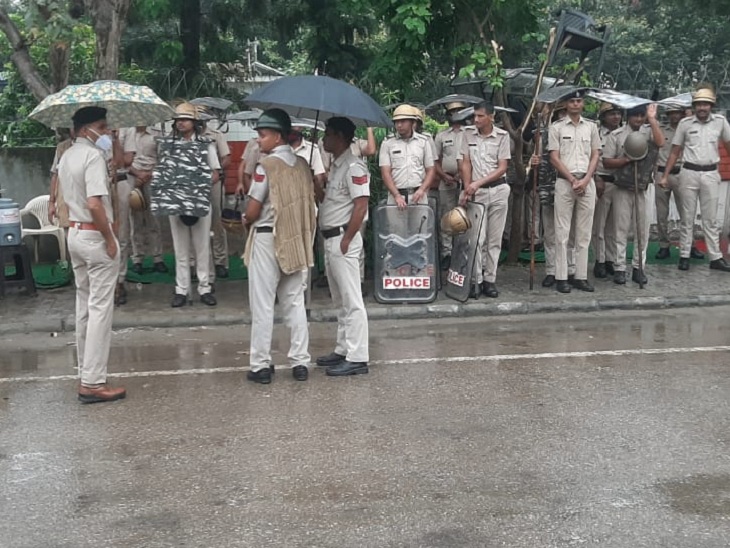 बारिश के बीच ड्यूटी पर डटे पुलिस कर्मी।