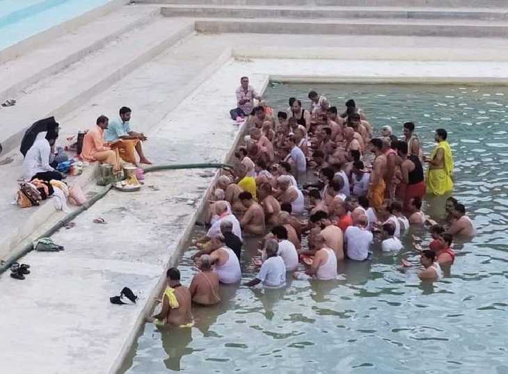 बीकानेर के धरणीधर तालाब में पानी आने के बाद श्रावणी कर्म करते लोग।