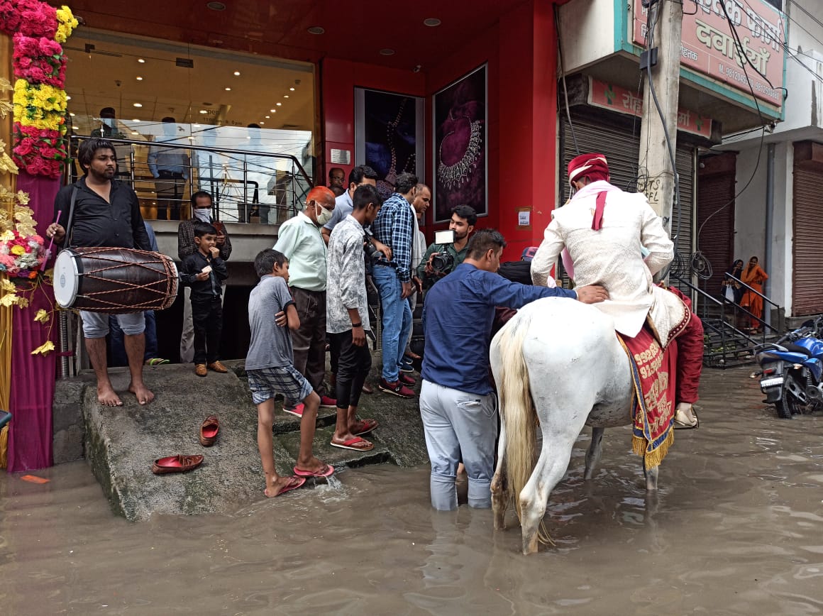 बसराती पानी जमा होने से नीचे उतरने का रास्ता देखता दूल्हा।