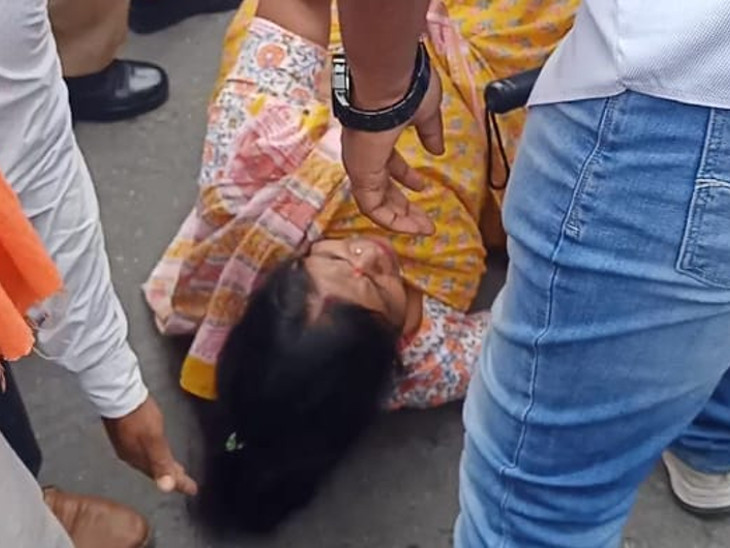झड़प के दौरान एक कार्यकर्ता सड़क पर गिर गई।