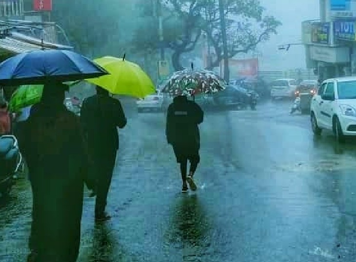 उदयपुर क्षेत्र में तेज बारिश के बीच जाते लोग।