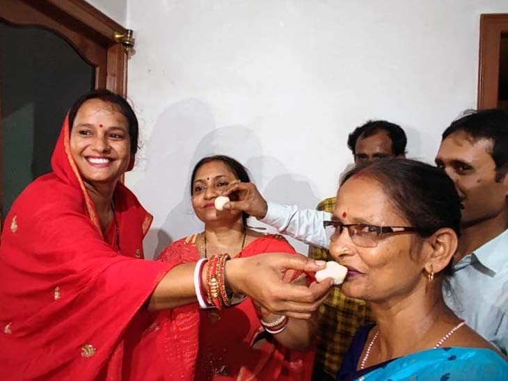 एक-दूसरे को मिठाई खिला खुशी व्यक्त करते शुभम के परिजन।