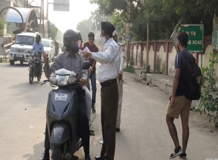 चौमूं सर्किल पर अभ्यर्थियों को पता बताने में सहयोग करते हुए आरएसएस स्वयंसेवक।