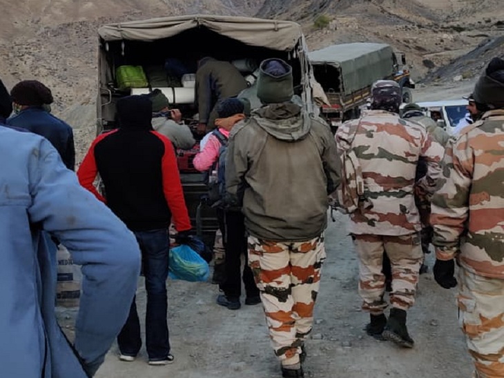 पर्वतरोहियों को वापस लेकर जाते बचाव दल के सदस्य।