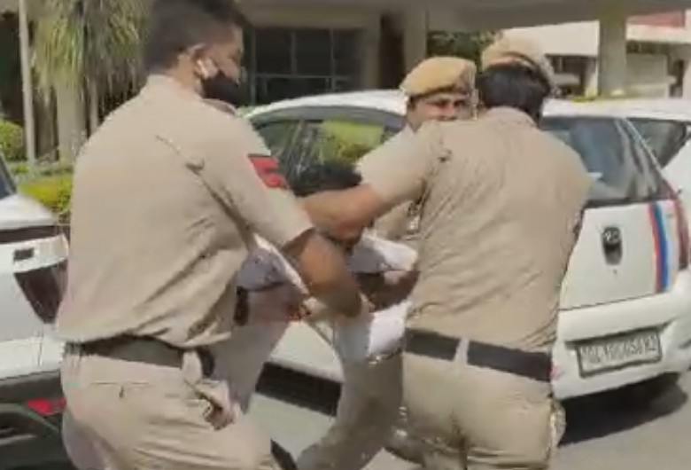 लड़की के पिता को घसीटकर ले जाते पुलिसकर्मी।