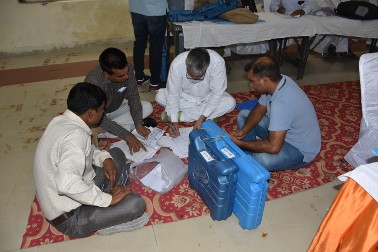 वोटिंग के लिए सामान संभालते हुए अधिकारी व कर्मचारी।