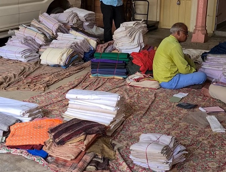 गांधी जयंती पर खादी वस्त्रों को बिक्री के लिए निकालते कर्मचारी।