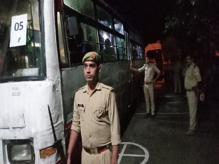 आजमगढ़ जेल में बलिया जेल से कैदियों को लेकर आई बस कैदियों की निगरानी करते पुलिस के जवान।