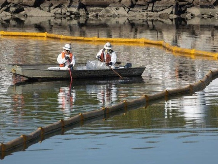 Workers cleaning up oil spilled in the sea.