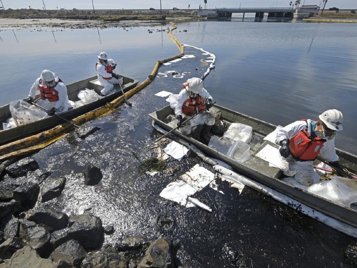 Workers extracting oil and garbage from the sea