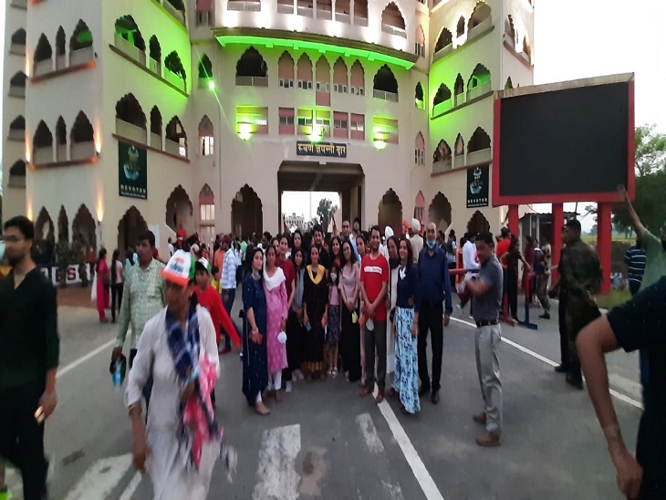 रिट्रीट खत्म होने के बाद तिरंगे के रंग में रंगे स्वर्ण द्वार के आगे तस्वीर लेते हुए सैलानी।