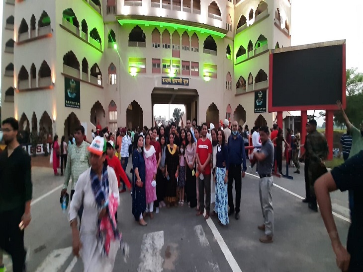 After the retreat, tourists take a picture in front of the golden gate painted in the colors of the tricolor.