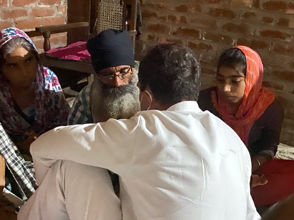 पलिया में लवप्रीत के माता-पिता से बातचीत करते राहुल गांधी।