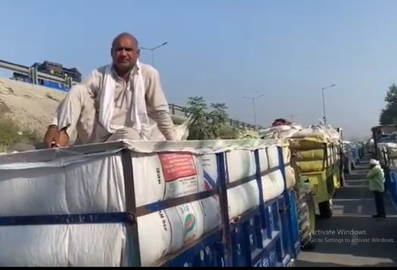 अपनी बारी आना का इंतजार करते हुए ट्राली में बैठा किसान।