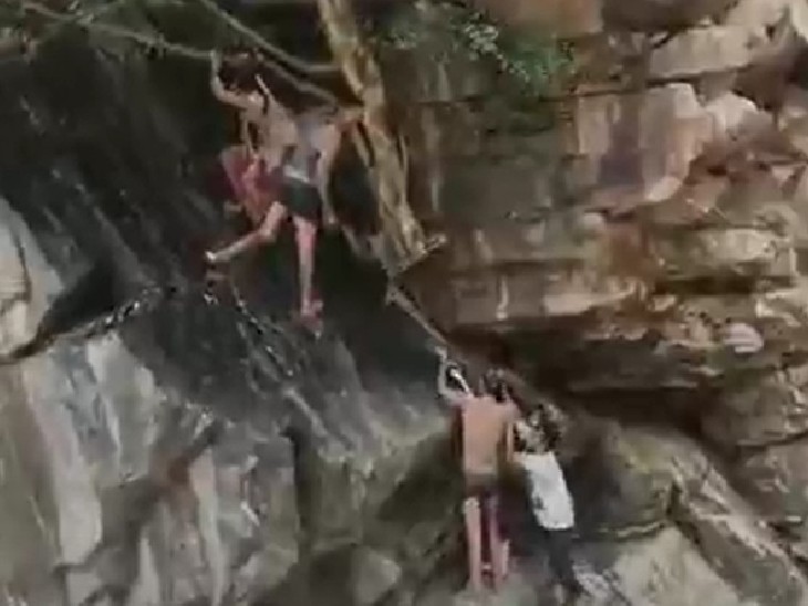 महिला और बच्चे को बचाने के लिए दो लोग फिसलन भरी चट्टानों पर चढ़ गए और उन्हें रेस्क्यू किया।