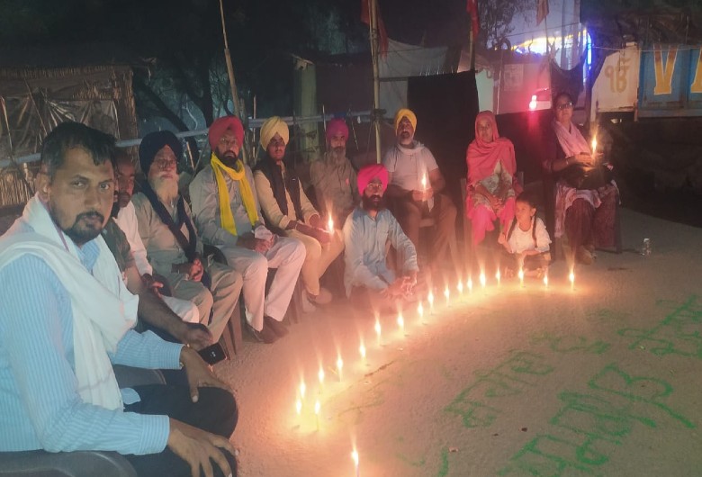 सिंधु बॉर्डर पर दीप जलाते किसान।