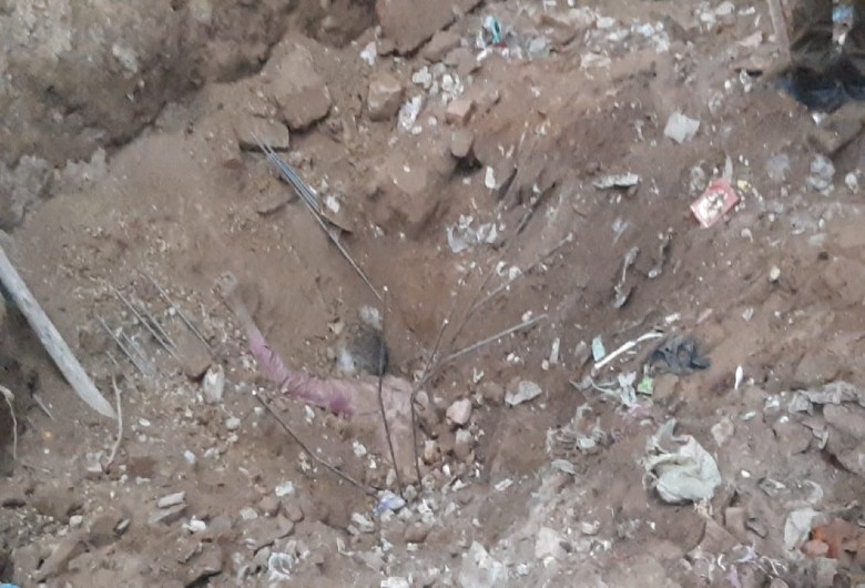रेवाड़ी में मिट्टी खिसकने के बाद नीचे दबा हुआ मजदूर।