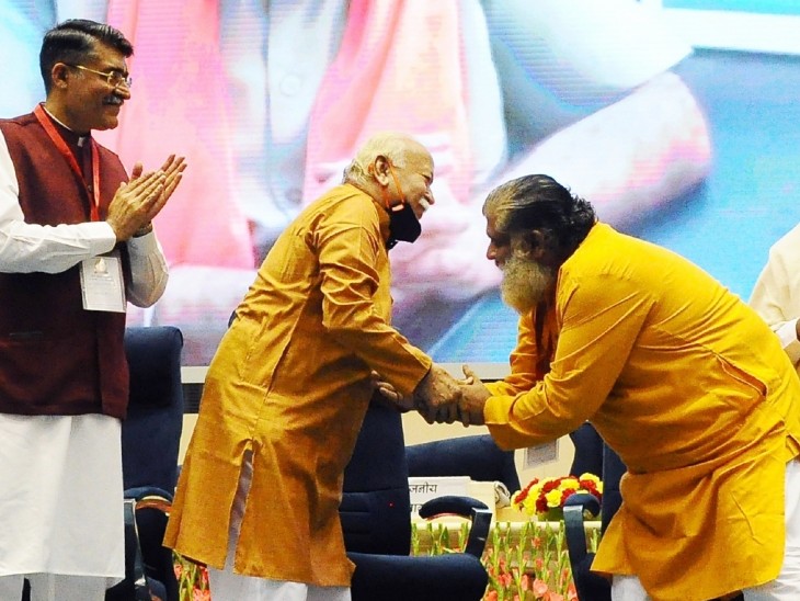 दिल्ली में कार्यक्रम के दौरान RSS चीफ मोहन भागवत के पैर छूने का प्रयास करते एक नेता।