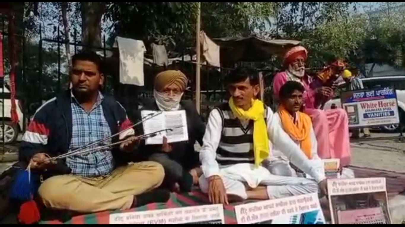 जिला चुनाव अधिकारी के कार्यालय समक्ष चपटे और बीन बजाकर प्रदर्शन करते हुए टीटू बनिया
