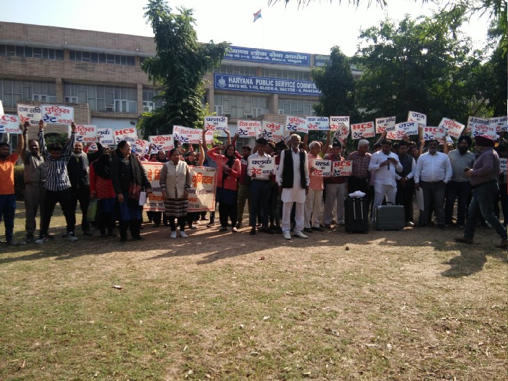 एचपीएससी कार्यालय के बाहर खड़े प्रदर्शनकारी।