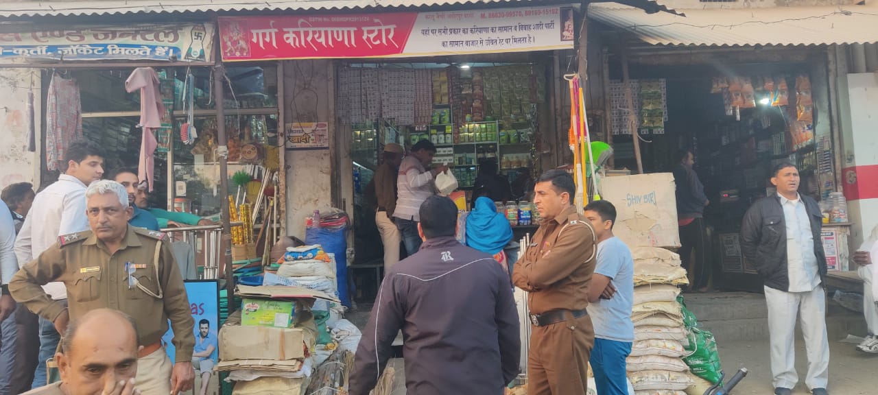 दुकान पर कार्रवाई करती हुई पुलिस व खाद्य आपूर्ति विभाग की टीम।