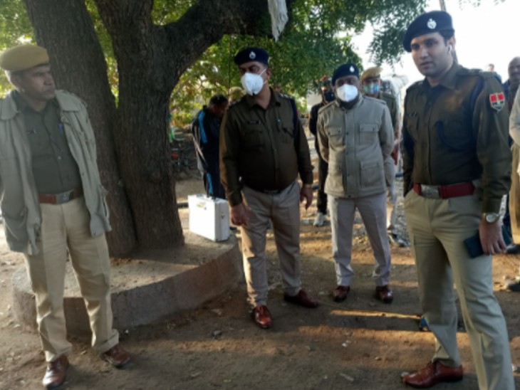 जांच करते पुलिस अफसर।