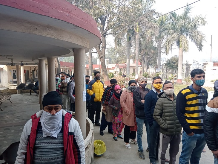 वैक्सीनेशन सेंटर पर लगी टीकाकरण करवाने के लिए लंबी लाइन।