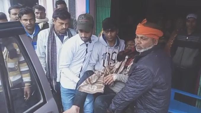 घायल पिता को इलाज के लिए ले जाते स्थानीय लोग।