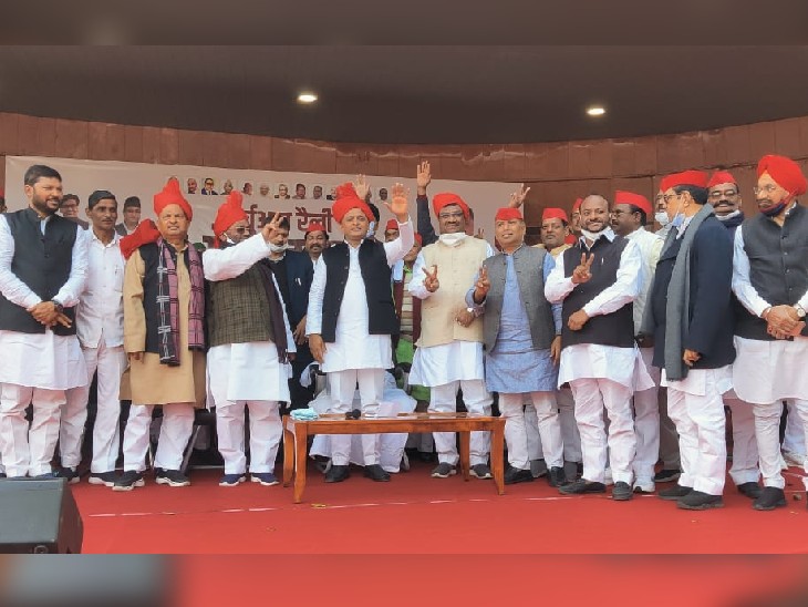 सपा के मंच पर आए भाजपा नेताओं को लाल पगड़ी और टोपी पहनाई गई।
