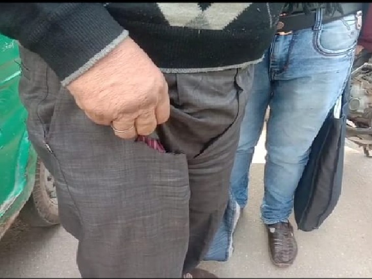 अपनी कटी हुई जेब दिखाता व्यवसायी
