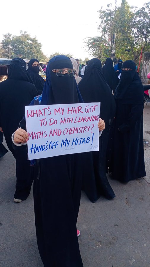 विरोध प्रदर्शन में शामिल एक स्टूडेंट के कार्ड पर लिखा-मैथ्स कैमिस्ट्री पढ़ने के लिए बालों का क्या करना है।