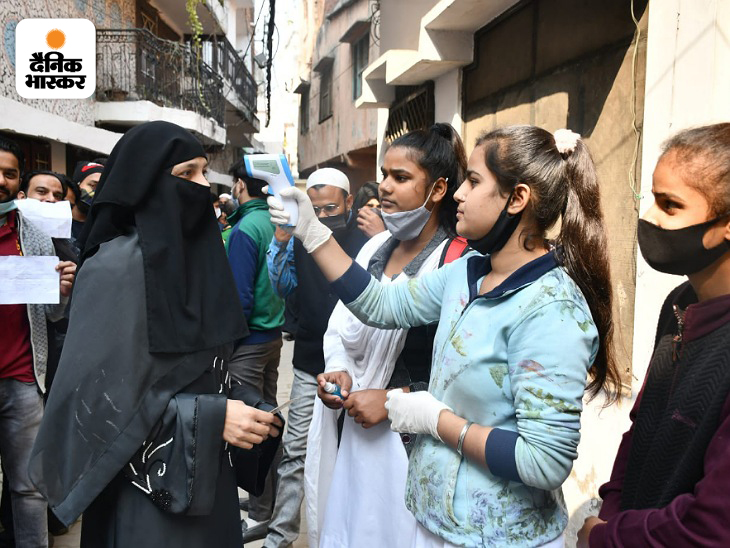 फोटो मुरादाबाद के एक पोलिंग बूथ की है, जहां स्वास्थ्यकर्मी महिला वोटर का टेम्परेचर चेक कर रही है। - उमेश शर्मा