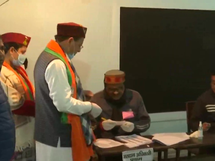 बूथ में निर्वाचन लिस्ट में अपना नाम चेक कराते मुख्यमंत्री धामी।