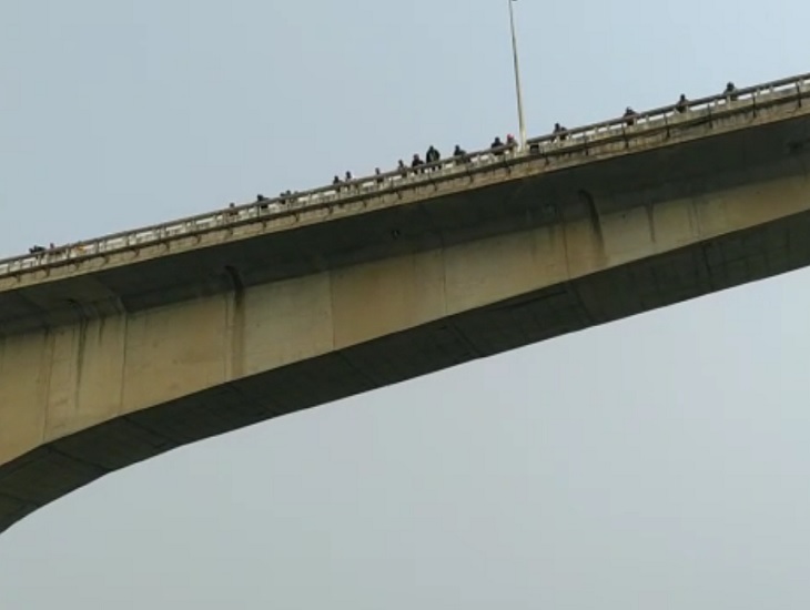 ऊपर पुल से देखते लोग।